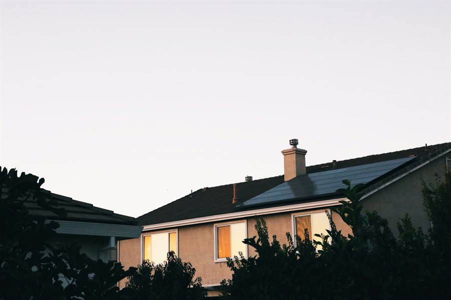 Casa com sistema fotovoltaico instalado no telhado ao entardecer